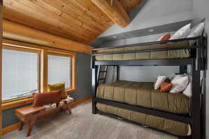 Carpeted bedroom featuring baseboards and wooden ceiling