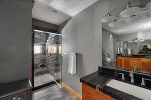 Full bath featuring a stall shower, baseboards, and vanity