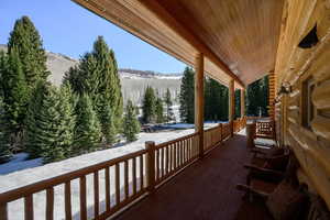Snow covered deck featuring covered porch and a mountain view