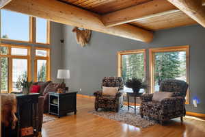 Living room featuring wooden ceiling, plenty of natural light, wood finished floors, and beamed ceiling