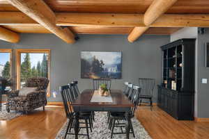 Dining space with light wood-type flooring, wooden ceiling, beamed ceiling, and baseboards