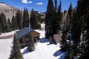 View of snow covered exterior featuring a view of trees and a mountain view