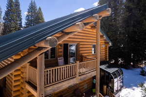 View of side of property featuring log exterior and metal roof