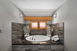 Bathroom with a whirlpool tub and backsplash