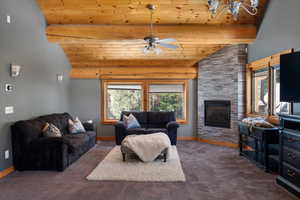 Carpeted living room featuring wooden ceiling, plenty of natural light, baseboards, ceiling fan, and high vaulted ceiling