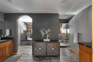 Full bath featuring vanity, baseboards, a stall shower, and a garden tub