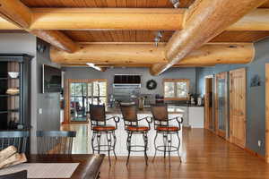 Dining area featuring wood ceiling, wood finished floors, beam ceiling, and plenty of natural light