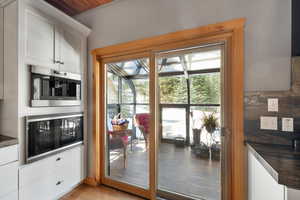 Doorway with light wood finished floors and baseboards