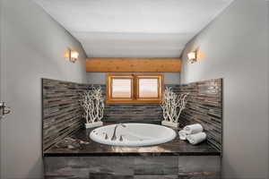 Bathroom with a jetted tub and tasteful backsplash