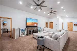 Living room featuring light colored carpet, vaulted ceiling high, and ceiling fan