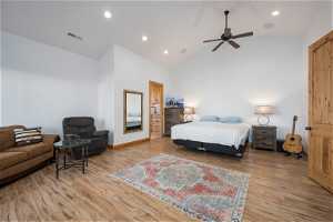 Hardwood floored bedroom with vaulted ceiling high and ceiling fan