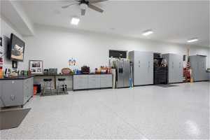 Garage featuring stainless steel fridge and ceiling fan