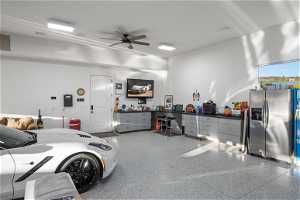 Garage featuring a workshop area, ceiling fan, and stainless steel fridge