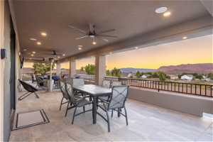 Patio terrace at dusk with ceiling fan and a mountain view