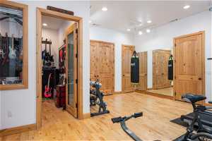 Workout area featuring light hardwood floors