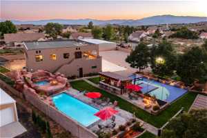 Pool at dusk with a patio area, an outdoor fire pit, and a mountain view