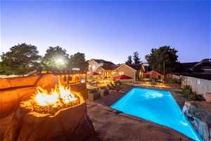 Pool at dusk featuring an outdoor fire pit