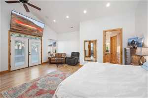Bedroom featuring access to outside, french doors, vaulted ceiling high, ceiling fan, and light hardwood flooring
