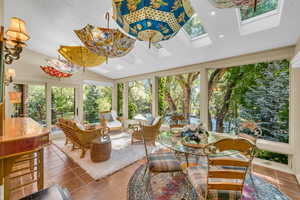 Sunroom / solarium featuring lofted ceiling with skylight