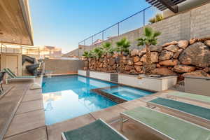 View of pool with an in ground hot tub