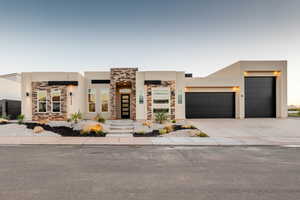 Pueblo-style house featuring a garage and central air condition unit