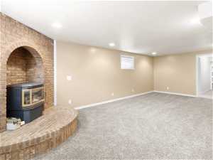 Unfurnished living room with a wood stove, carpet, and a fireplace