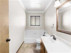 Bathroom featuring tile flooring, ornamental molding, toilet, oversized vanity, and a bathing tub