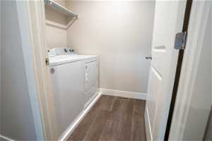 Washroom with independent washer and dryer and dark hardwood flooring