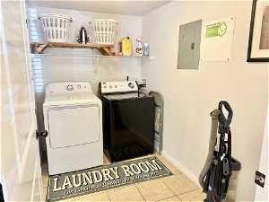 Washroom featuring washing machine and clothes dryer, hookup for a washing machine, and light tile floors
