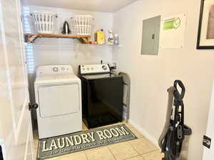 Washroom featuring washing machine and clothes dryer, hookup for a washing machine, and light tile floors