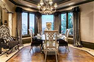 Dining area featuring a healthy amount of sunlight, dark hardwood floors, and an inviting chandelier