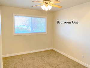 Carpeted spare room with ceiling fan and a healthy amount of sunlight