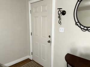 Doorway to outside with dark hardwood / wood-style flooring