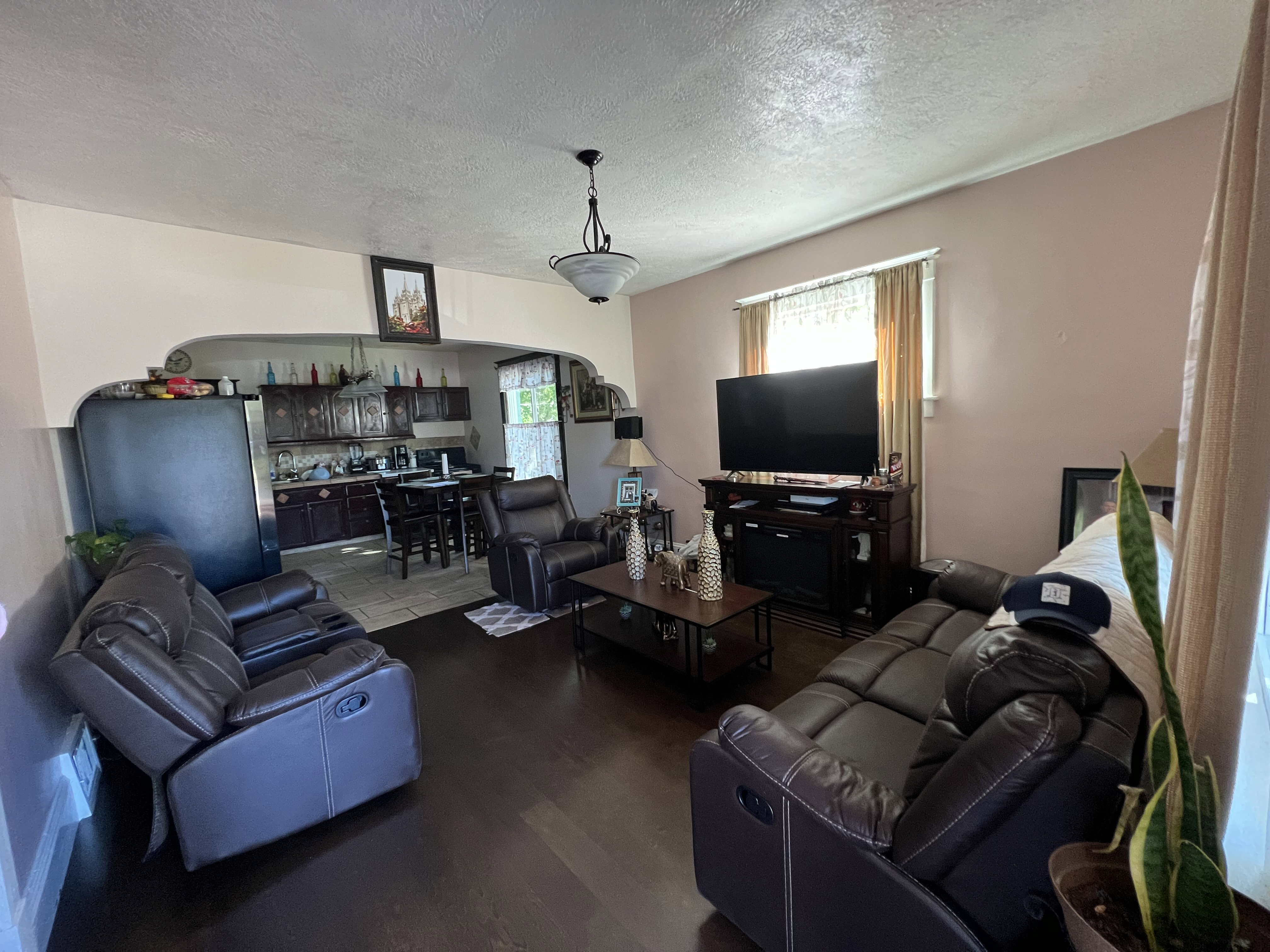 Living room featuring a textured ceiling and dark wood-type flooring