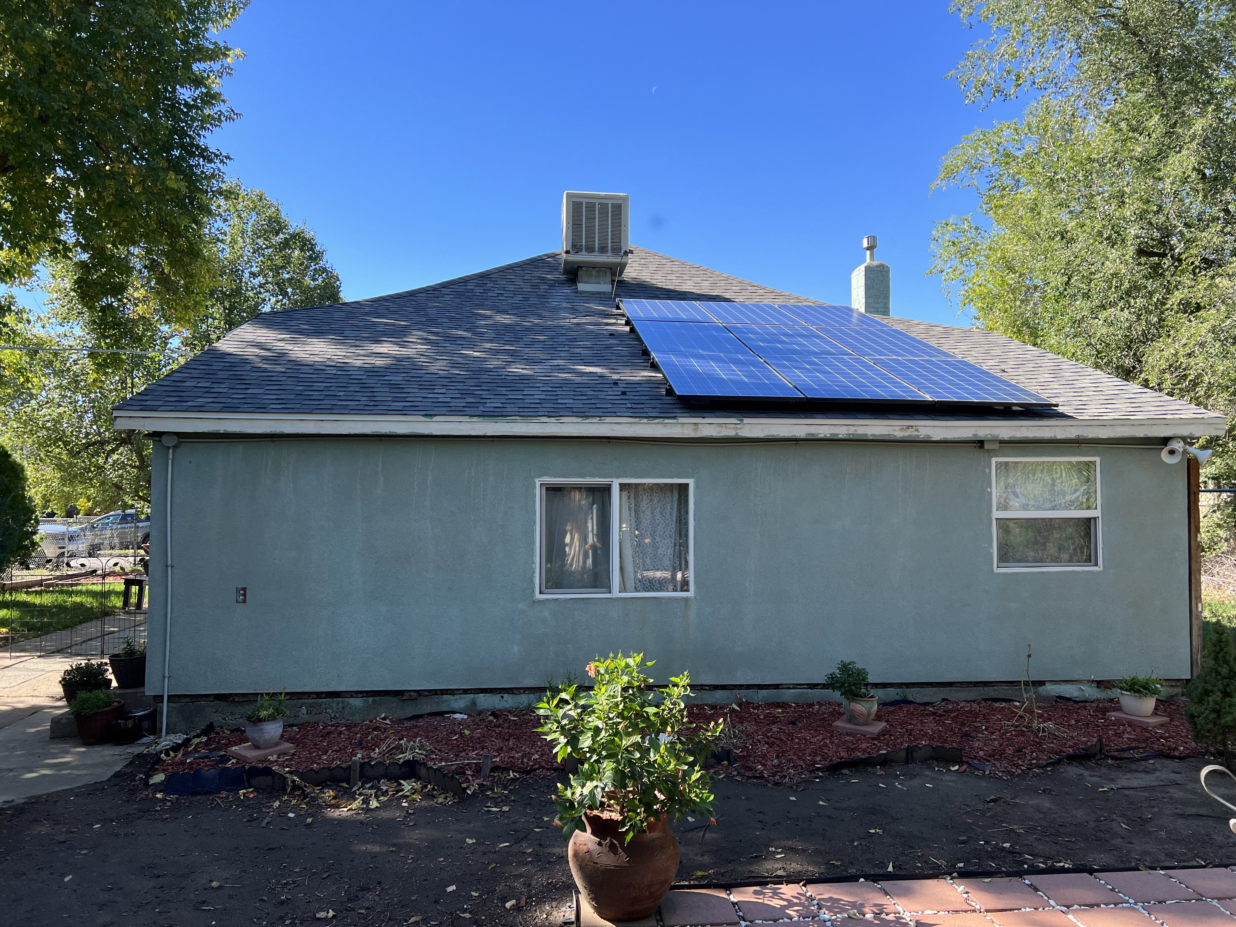 View of side of home featuring central AC and solar panels