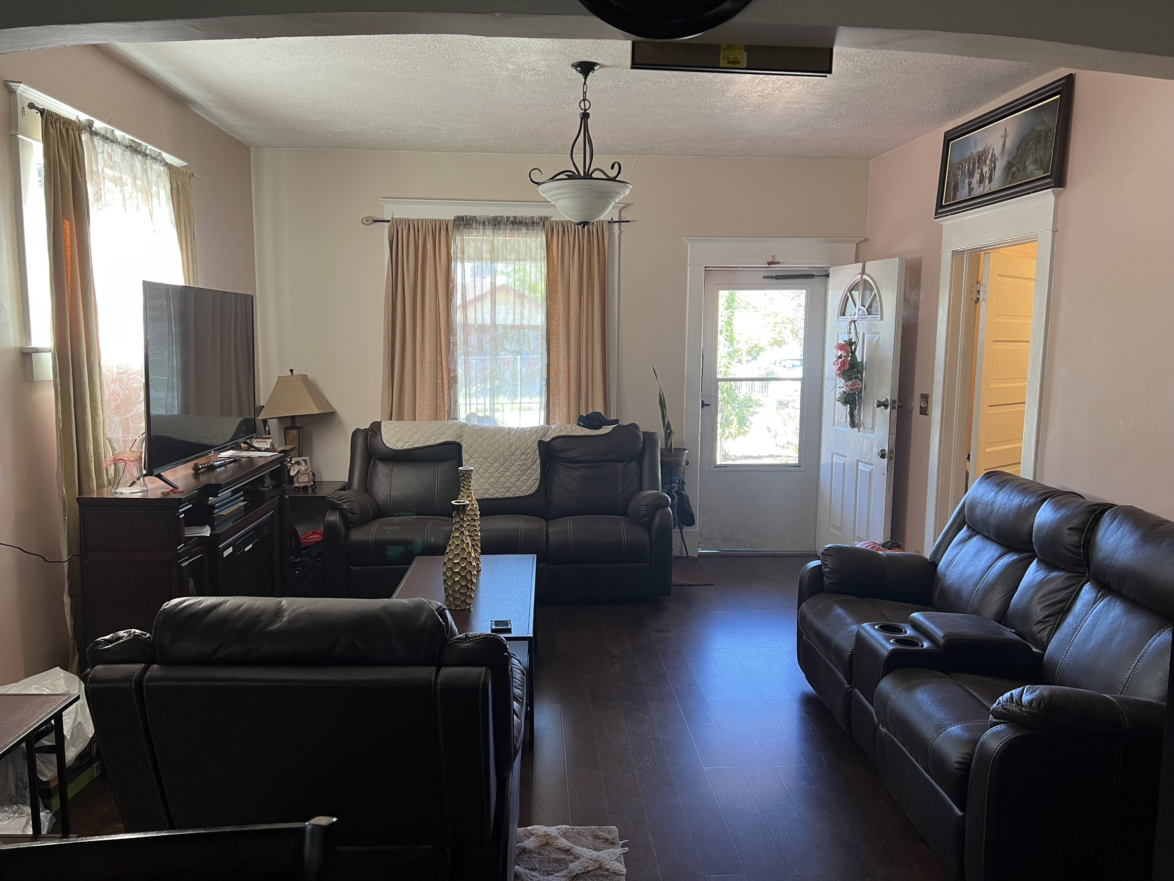 Living room featuring dark hardwood / wood-style flooring and a textured ceiling