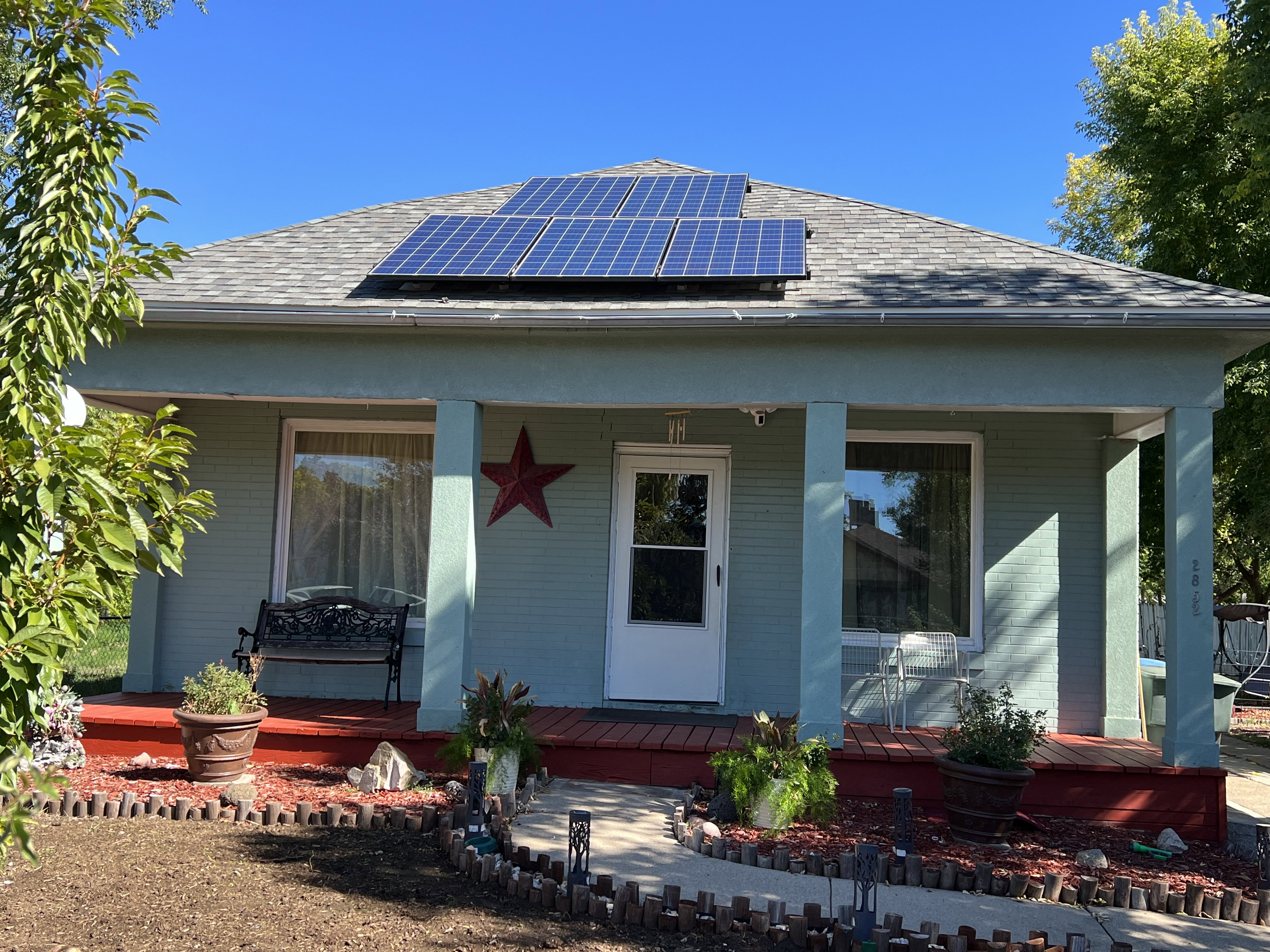 View of front of house with solar panels and covered porch