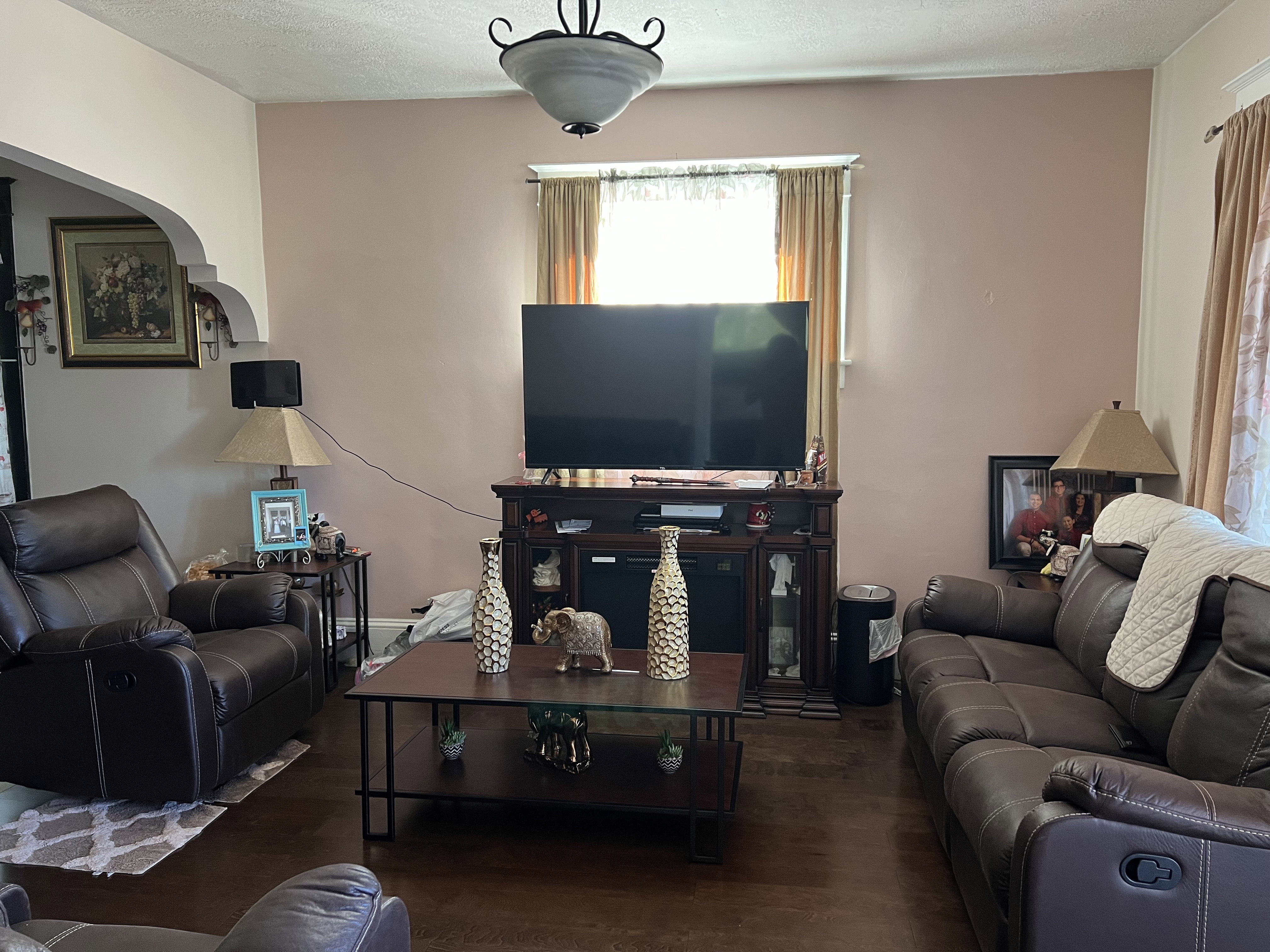 Living room with a textured ceiling and dark wood-type flooring