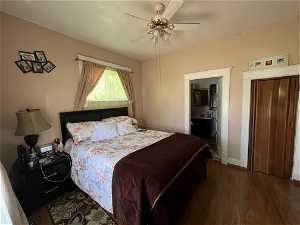 Bedroom featuring ceiling fan, dark hardwood / wood-style flooring, and ensuite bath
