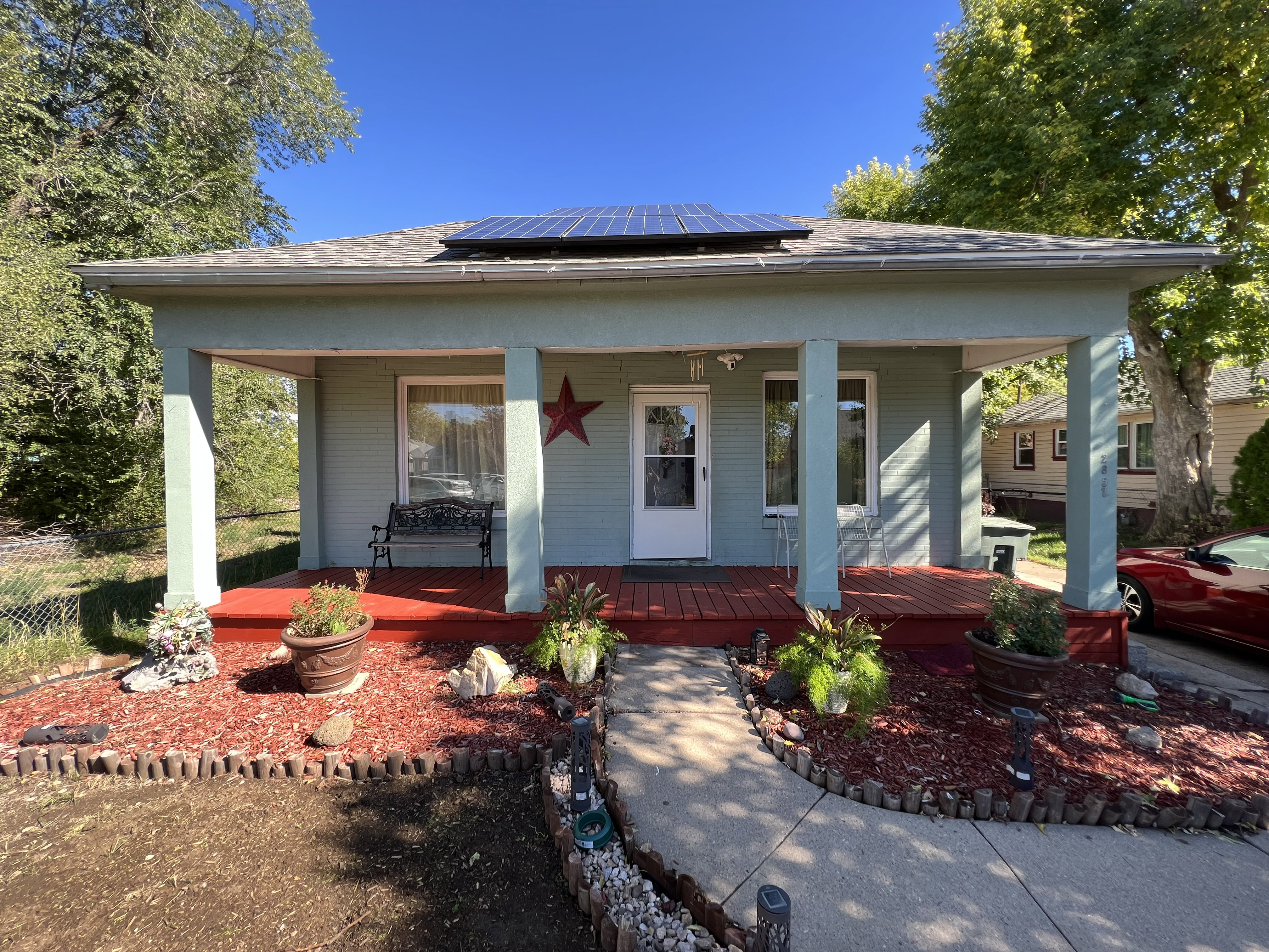View of front of property featuring solar panels and covered porch