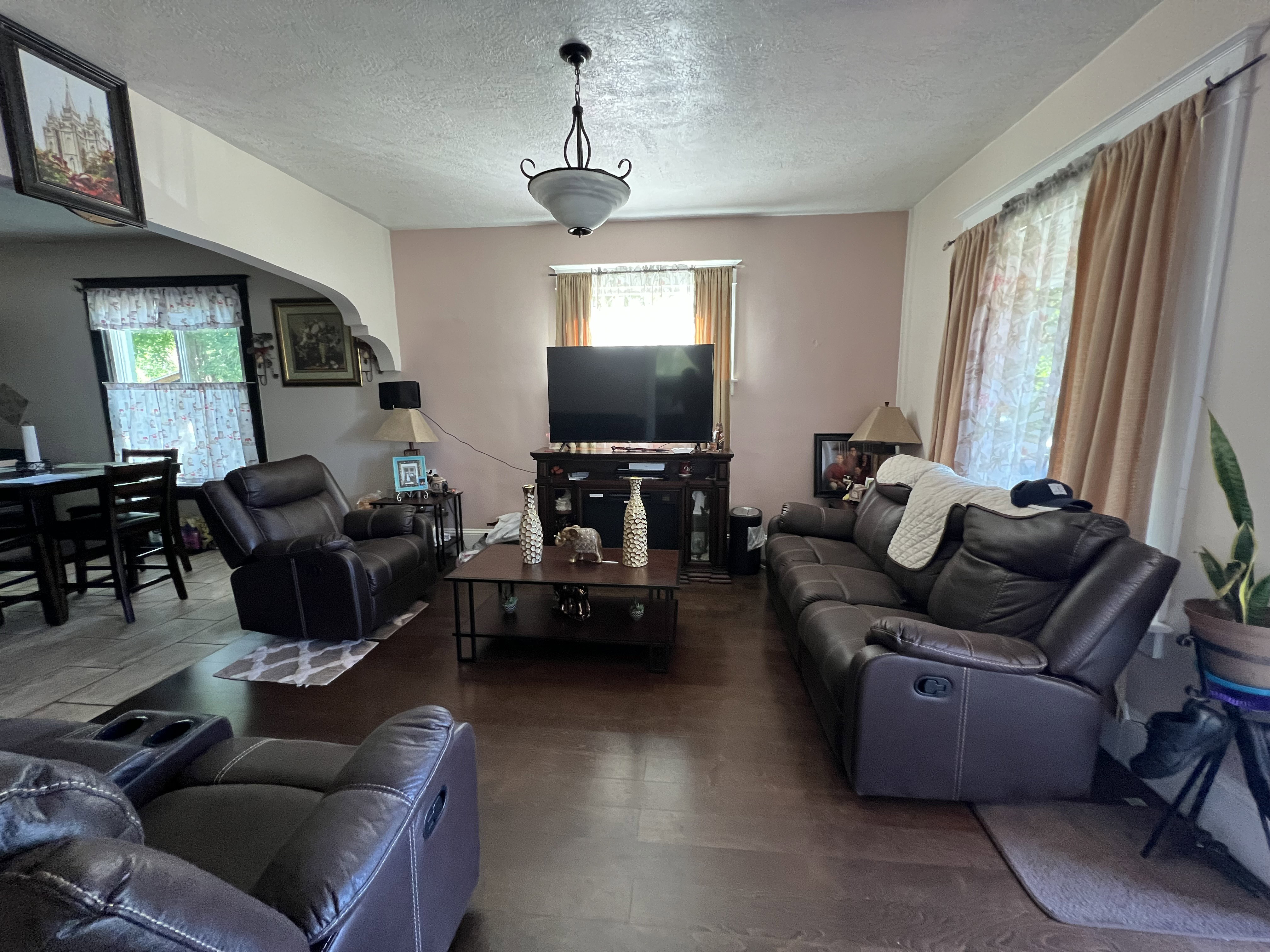 Living room featuring hardwood / wood-style flooring, a textured ceiling, and a healthy amount of sunlight