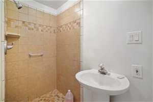 Bathroom featuring tiled shower and sink