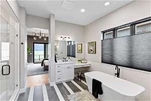 Bathroom featuring an inviting chandelier, large vanity, hardwood / wood-style flooring, and plus walk in shower