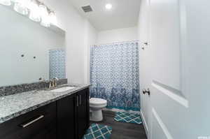 Bathroom featuring hardwood / wood-style flooring, vanity, and toilet