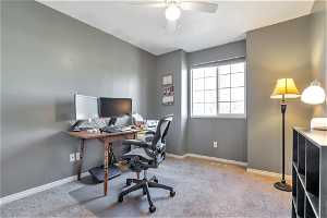 Home office with ceiling fan and light carpet