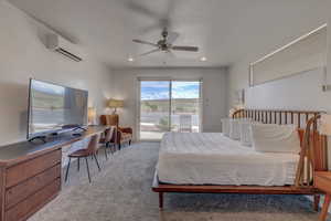 Carpeted bedroom with access to exterior, ceiling fan, and a wall mounted AC