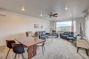 Living room with a wall mounted AC and ceiling fan