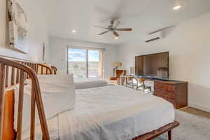 Carpeted bedroom featuring ceiling fan and a wall unit AC