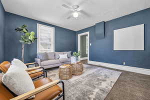 Living room with carpet flooring and ceiling fan