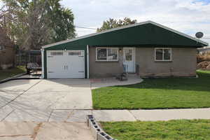 Ranch-style house with a garage and a front lawn